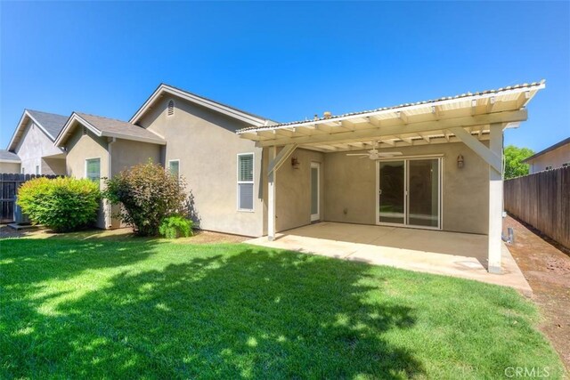 back of house featuring ceiling fan, fence, stucco siding, a patio area, and a yard