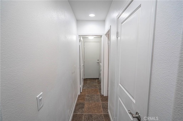 corridor with recessed lighting and stone tile flooring