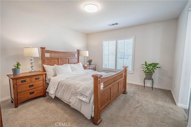 bedroom featuring baseboards, visible vents, and light carpet