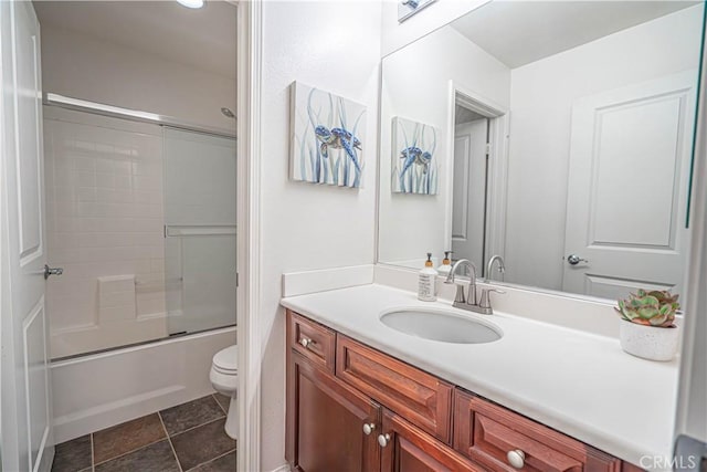full bath with vanity, combined bath / shower with glass door, and toilet