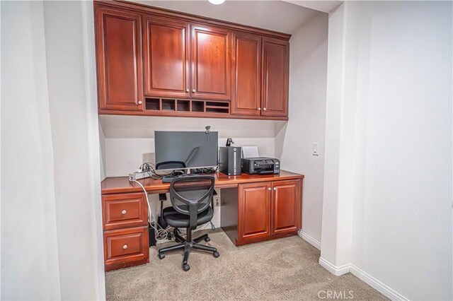 office space with baseboards and light colored carpet