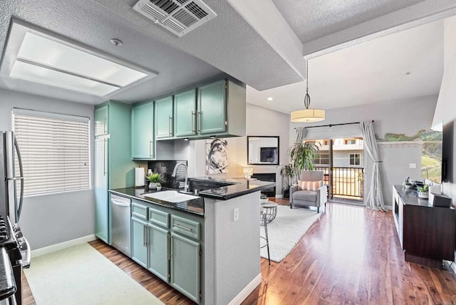 4658 Ohio St, San Diego, CA 92116 - kitchen featuring dark countertops, a sink, appliances with stainless steel finishes, wood finished floors, and healthy amount of natural light