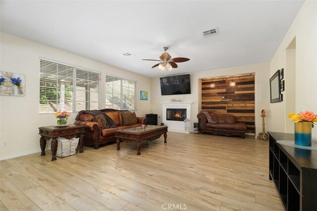 34787 Grotto Hills Dr, Winchester, CA 92596 - living area featuring visible vents, light wood-style floors, ceiling fan, and a glass covered fireplace