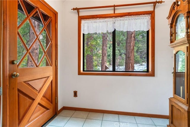doorway to outside featuring light tile patterned floors and baseboards
