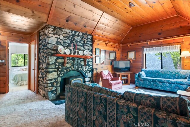living room with a wood stove, wooden walls, wood ceiling, carpet, and vaulted ceiling