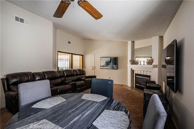 749 Cortez Dr, Hemet, CA 92545 - carpeted dining space featuring visible vents, a ceiling fan, a textured ceiling, and a tile fireplace
