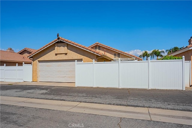 749 Cortez Dr, Hemet, CA 92545 - view of front of house with stucco siding, a garage, fence, and a tiled roof