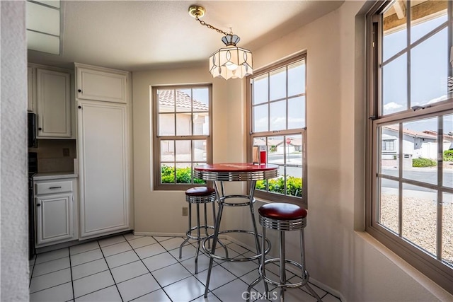 749 Cortez Dr, Hemet, CA 92545 - dining area featuring light tile patterned flooring, baseboards, and a chandelier