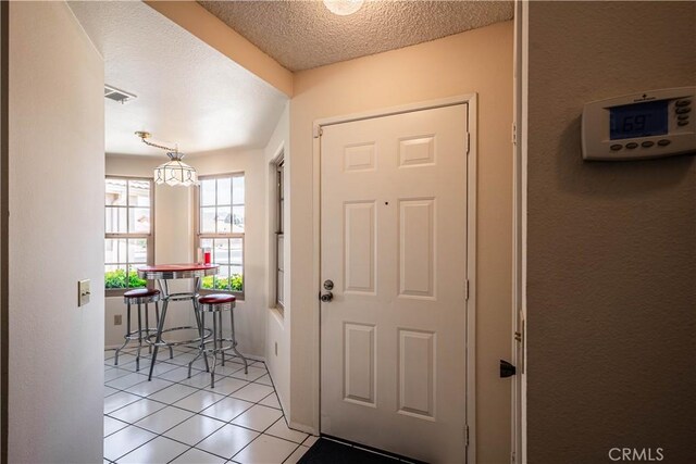 749 Cortez Dr, Hemet, CA 92545 - doorway featuring light tile patterned floors, a textured ceiling, and visible vents