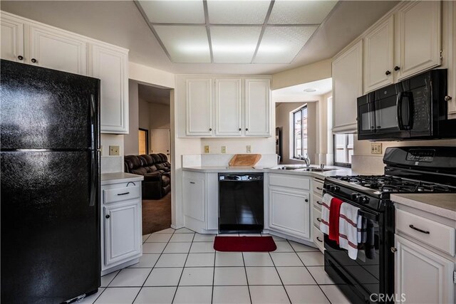 749 Cortez Dr, Hemet, CA 92545 - kitchen with light countertops, a sink, black appliances, and white cabinetry