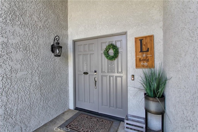 doorway to property featuring stucco siding