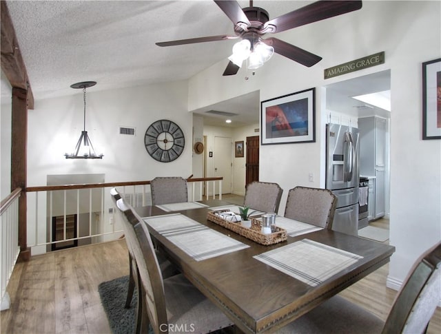dining area with a ceiling fan, visible vents, vaulted ceiling, baseboards, and light wood-style floors