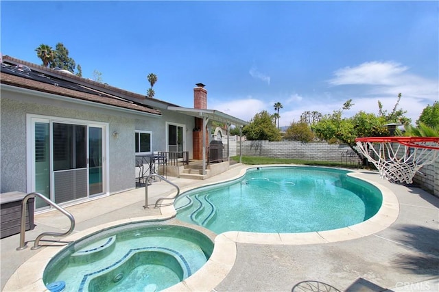 view of pool featuring a patio, a pool with connected hot tub, and a fenced backyard