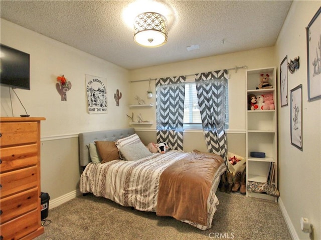 bedroom with baseboards, carpet, and a textured ceiling