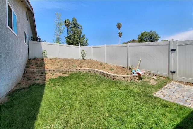 view of yard with a fenced backyard and a gate