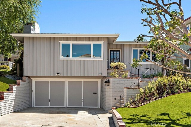 309 W Avenida Valencia, San Clemente, CA 92672 - view of front facade featuring a garage, a front lawn, a chimney, board and batten siding, and concrete driveway