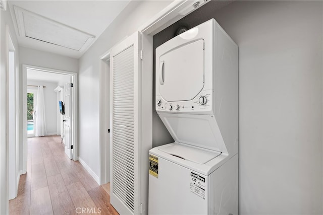 309 W Avenida Valencia, San Clemente, CA 92672 - clothes washing area featuring laundry area, attic access, stacked washer / drying machine, baseboards, and light wood-style floors