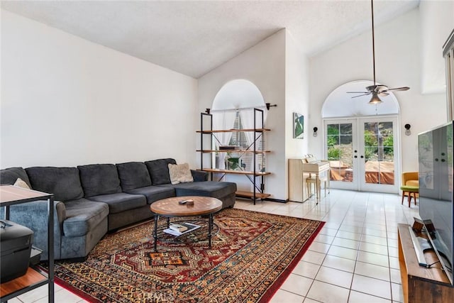 living area featuring ceiling fan, high vaulted ceiling, a textured ceiling, french doors, and light tile patterned floors