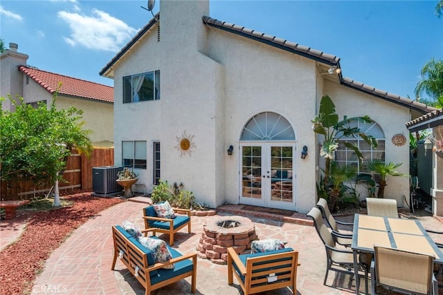 back of property featuring a fire pit, cooling unit, stucco siding, french doors, and a patio area