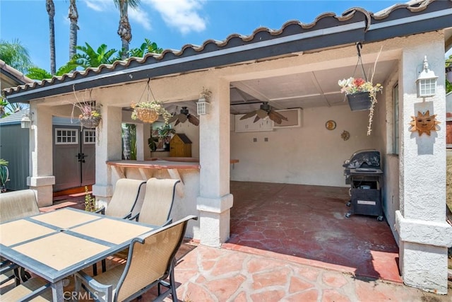 view of patio featuring a bar, outdoor dining space, and ceiling fan