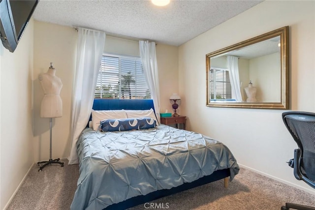 carpeted bedroom with a textured ceiling and baseboards