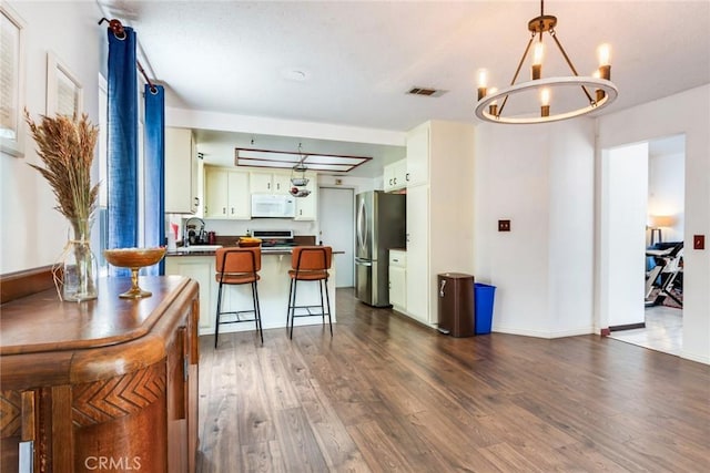 interior space with baseboards, dark wood-style floors, a chandelier, and visible vents