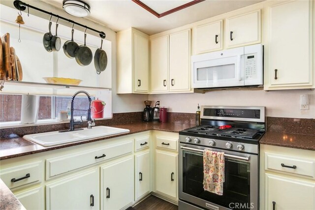 kitchen with a sink, gas stove, and white microwave