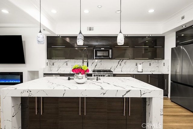 kitchen with black microwave, built in fridge, backsplash, visible vents, and modern cabinets