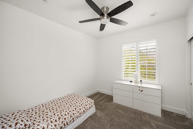 bedroom featuring dark carpet, a ceiling fan, and baseboards