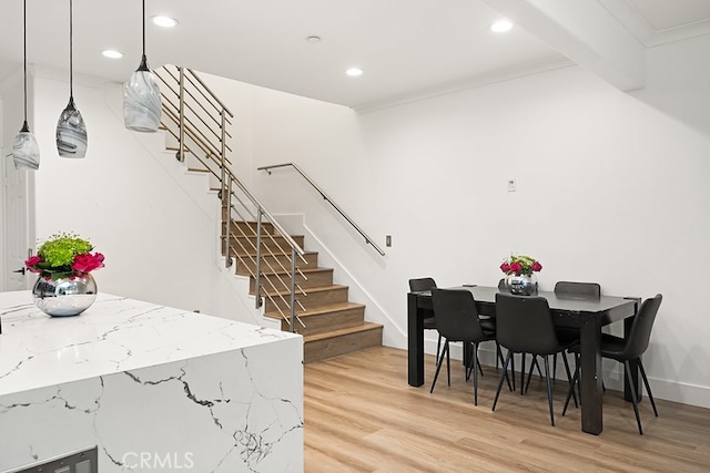 dining area featuring light wood-type flooring, recessed lighting, stairs, and baseboards