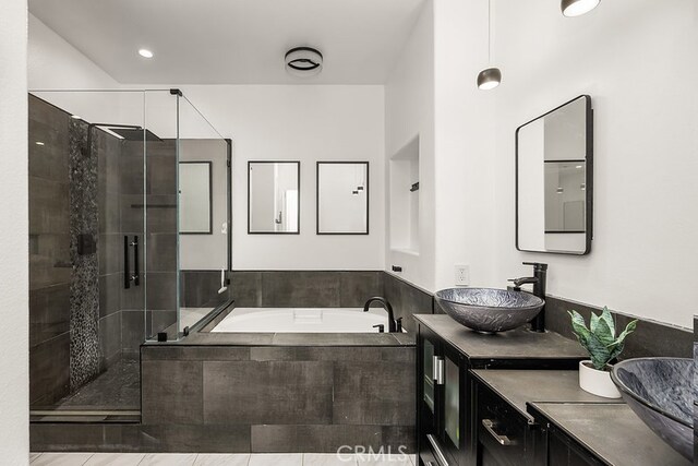 full bathroom with a garden tub, a sink, a stall shower, and double vanity