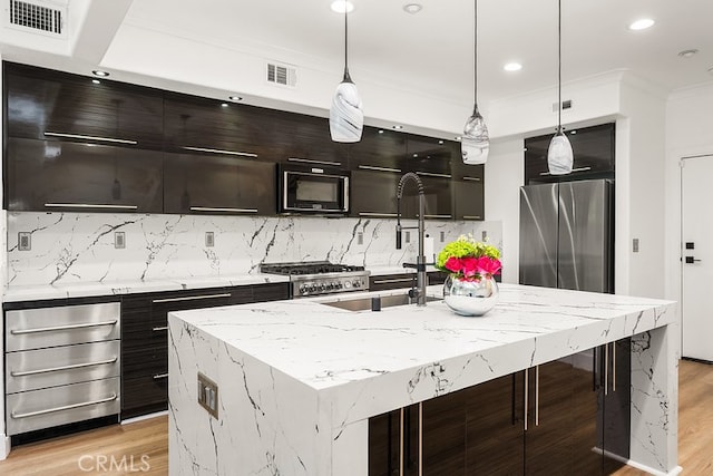 kitchen featuring freestanding refrigerator, recessed lighting, a sink, light wood finished floors, and backsplash