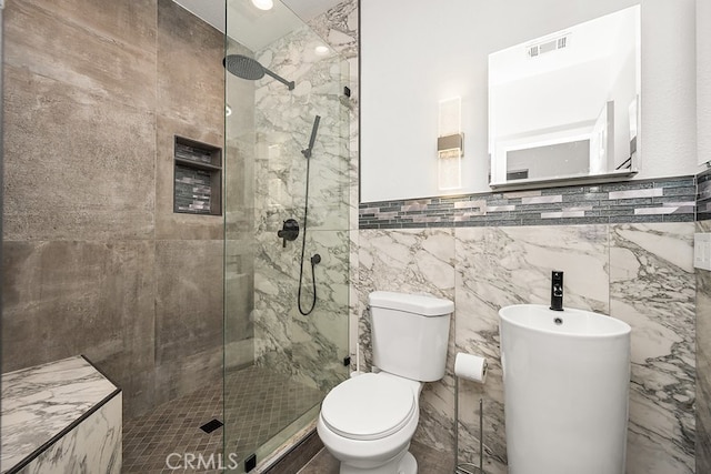 full bathroom featuring a tile shower, toilet, and visible vents