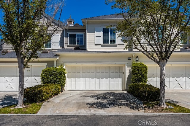 multi unit property with an attached garage and driveway