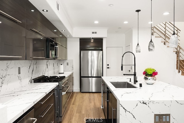 kitchen featuring a sink, light wood-style flooring, stainless steel appliances, recessed lighting, and decorative backsplash