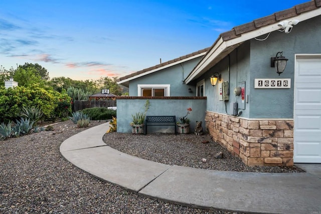 16016 Spangler Peak Rd, Ramona, CA 92065 - doorway to property featuring fence, stucco siding, a tiled roof, and stone siding