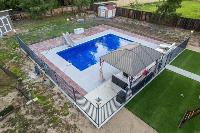 16016 Spangler Peak Rd, Ramona, CA 92065 - view of swimming pool with a storage unit, a fenced backyard, a water slide, and an outbuilding