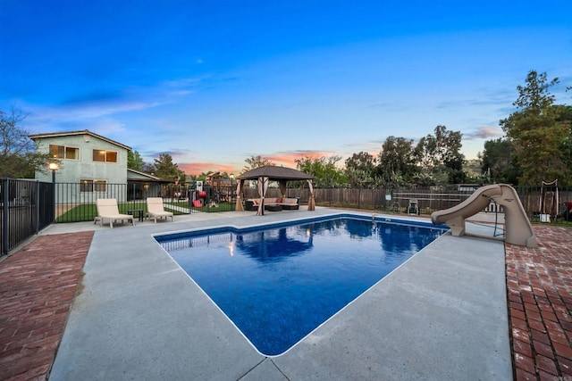 16016 Spangler Peak Rd, Ramona, CA 92065 - pool at dusk featuring fence, a water slide, and a gazebo