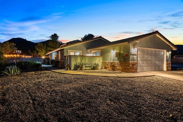 16016 Spangler Peak Rd, Ramona, CA 92065 - view of front facade with fence, stone siding, an attached garage, a mountain view, and driveway