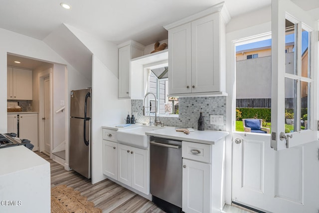 3534 Ocean Dr, Oxnard, CA 93035 - kitchen featuring decorative backsplash, light wood-type flooring, light countertops, a sink, and stainless steel appliances