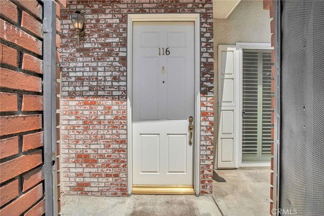 view of exterior entry with brick siding