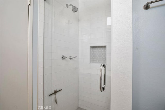 full bathroom with a textured wall and a shower stall