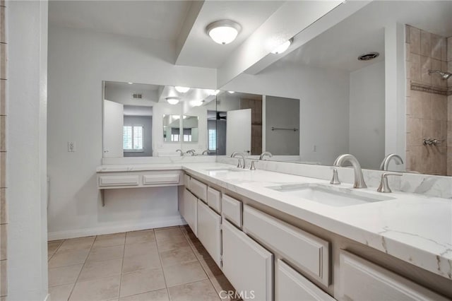 full bathroom with double vanity, a sink, baseboards, and tile patterned floors
