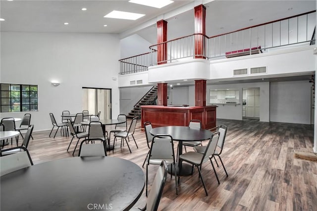10201 Mason Ave Unit 116, Chatsworth, CA 91311 - dining space with visible vents, stairs, wood finished floors, baseboards, and high vaulted ceiling