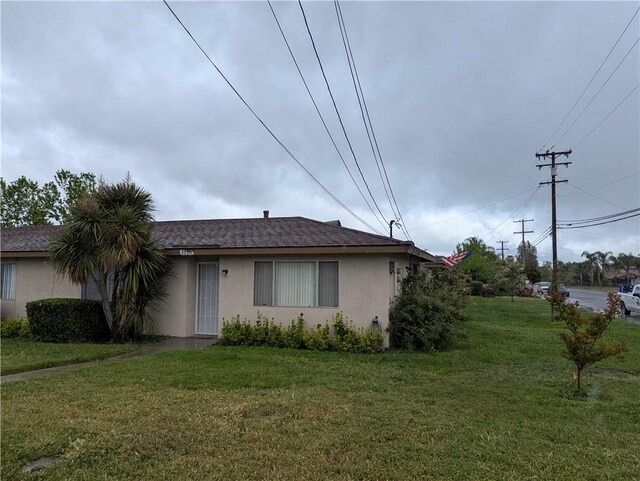 view of front of house with stucco siding and a front yard