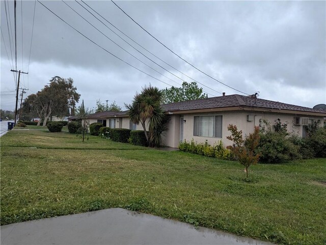 view of property exterior with a lawn and stucco siding