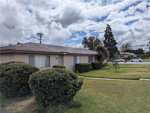 view of property exterior with stucco siding and a yard