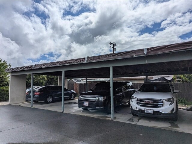 covered parking lot featuring fence