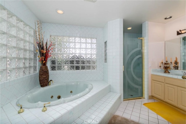 bathroom with a jetted tub, vanity, tile patterned flooring, and a shower stall