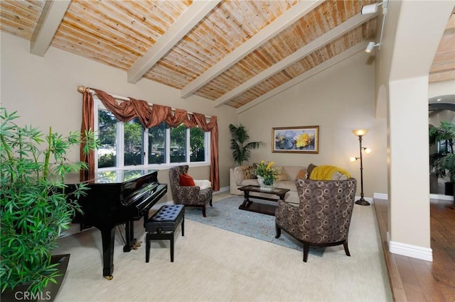living area with baseboards, beamed ceiling, wooden ceiling, and wood finished floors